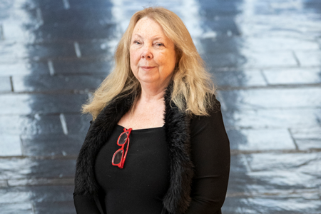 Photo of Teresa Head-Gordon, waist up, standing in the lobby of Stanley Hall, UC Berkeley