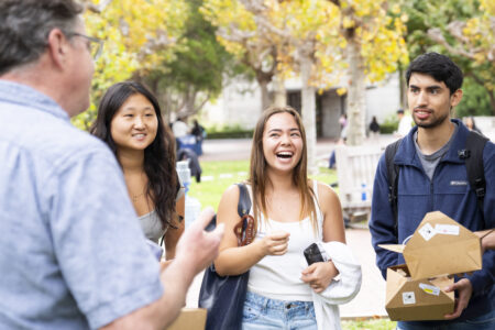 photo of Prof Messersmith talking to three students at 2024 fall welcome picnic