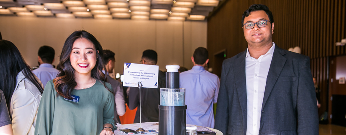Golnazshahmirzadi_Fung_May_10_2019_WebSize_80A9165-1-2 two MEng students standing with a demo of their capstone project at a table in an exhibition hall