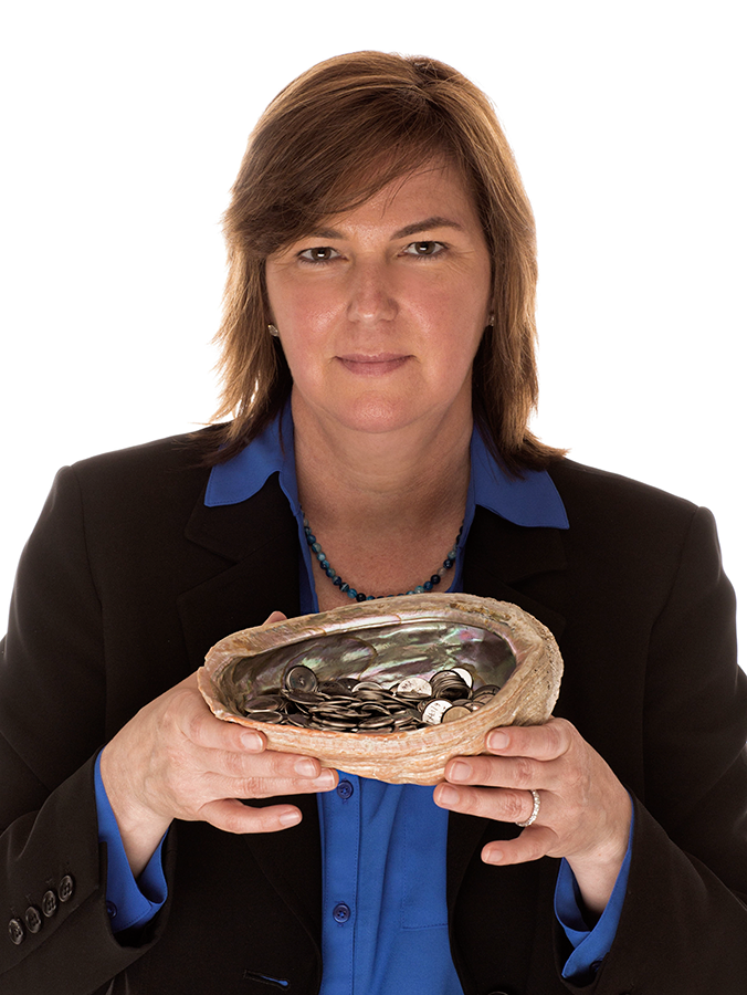 Photo of Angela Belcher, waist up, holding an abalone shell full of coins