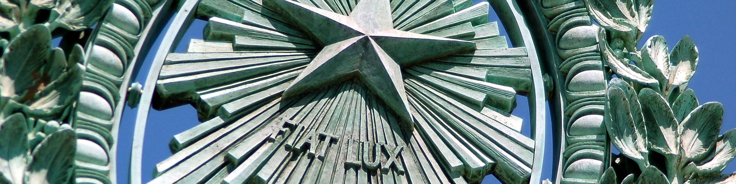 closely cropped horizontal photo of Fiat Lux star at the center of Sather Gate